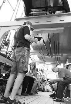  ??  ?? Seated beneath harpoons and a whaleboat, participan­ts in the ‘Moby-Dick’ marathon listen as a chapter is read aloud. — WP-Bloomberg photos