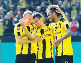  ??  ?? Dortmund’s Pierre-Emerick Aubameyang, right, is celebrated by teammates Sebastian Rode and Raphael Guerreiro after scoring Photo: AP