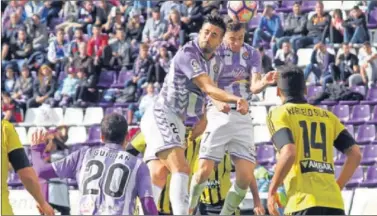  ??  ?? PUGNA. Álex Pérez y Juan Villar saltan por un balón durante el partido de ayer.