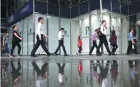  ?? REUTERS ?? Office workers pass a UOB branch in Singapore's central business district.