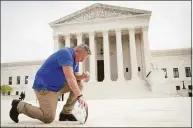  ?? Win McNamee / Getty Images ?? Former Bremerton High School assistant football coach Joe Kennedy takes a knee in front of the U.S. Supreme Court after his legal case, Kennedy vs. Bremerton School District, was argued before the court on April 25 in Washington, DC. Kennedy was terminated from his job by Bremerton public school officials in 2015 after refusing to stop his on-field prayers after football games. The court ruled 6-3 along ideologica­l lines for the coach. The justices said Monday the coach’s prayer was protected by the First Amendment.