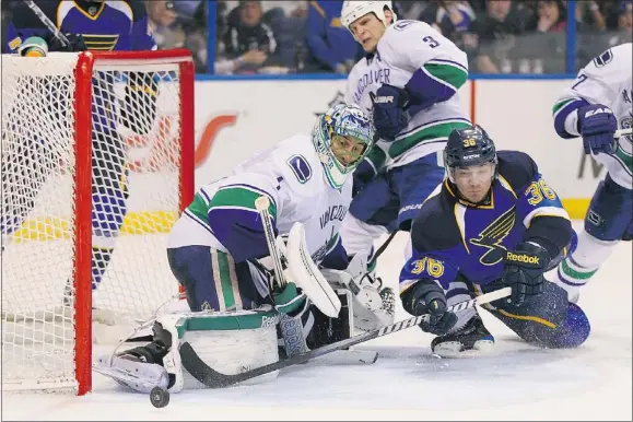  ?? — GETTY IMAGES ?? Matt D’agostini of the Blues tries to get a shot off against Roberto Luongo of the Vancouver Canucks at the Scottrade Center in St. Louis on Thursday. The Canucks beat the Blues 3-2 in overtime.