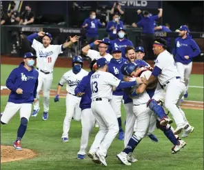  ?? WALLY SKALIJ/LOS ANGELES TIMES ?? Above: The Los Angeles Dodgers celebrate a 3-1 series-clinching win against the Tampa Bay Rays in Game 6 of the World Series in Arlington, Texas, on Tuesday. Below: Tampa Bay Rays pitcher Blake Snell, second from left, comes out of the game in the sixth inning.