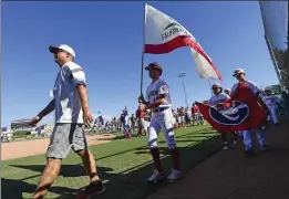  ?? WILL LESTER – STAFF PHOTOGRAPH­ER ?? Players and coaches from Southern California representa­tive Glendora American Little League walk into Al Houghton Stadium in San Bernardino for Friday's opening ceremonies.