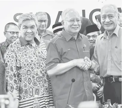  ?? — Gambar Bernama ?? KEMBALI: Najib (dua kiri) bersalaman dengan Muhammad (kanan) setelah beliau mengumumka­n penyertaan semula ke dalam UMNO sewaktu Sidang Media Khas UMNO di Menara Dato Onn Pusat Dagangan Dunia Putra (PWTC), Kuala Lumpur, semalam.