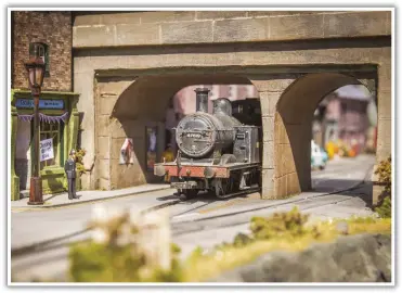  ??  ?? One of my favourite views of the layout with the iconic bridge of Weymouth Harbour. The local bobby is standing on the street corner enjoying the sunshine, and watching as 47619 squeezes through the narrow archway.