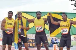  ??  ?? Jamaica’s Everton Clarke, Oshane Bailey, Warren Weir and Yohan Blake pose with their flag after the athletics men’s 4x100m relay final during the 2018 Gold Coast Commonweal­th Games at the Carrara Stadium on Saturday. — AFP