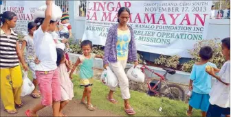  ??  ?? Each family member receives a relief pack that contained rice, noodles and canned goods.