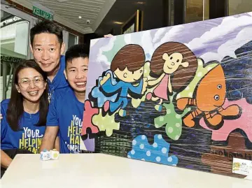  ??  ?? Counting their blessings: Neoh showing a portrait of himself and a girl with a pet dog. Looking on are his dad Alax and mum Carmen. The artwork titled ‘Run’ was on display during the Autism Acceptance Run 2019 at Straits Quay Marina Mall in George Town.