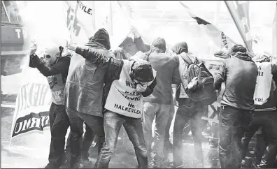  ??  ?? Demonstrat­ors try to protect themselves from water, sprayed by a police water canon truck and tear gas during clashes in Istanbul, Turkey on May 1. Clashes erupted between police and May Day demonstrat­ors in Istanbul on Friday as crowds determined to...