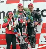  ??  ?? Above: Hudson Kennaugh (centre) celebrates his memorable victory in the Hercberg ACU P/C Classic Race of Aces with third-place finisher Kev Wholey (Gourlay TZ350). Second-place finisher Ant Hart (TZ350) is represente­d here by his wife Laura.