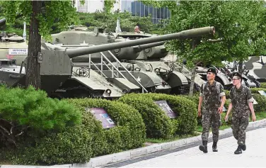  ?? — AP ?? Mending fences: South Korean soldiers walking past military vehicles at the Korea War Memorial Museum in Seoul. Moon has offered to hold military talks with North Korea.