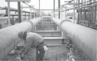  ?? Luke Sharrett / Bloomberg ?? A contractor works on oil pipeline infrastruc­ture at the U.S. Department of Energy’s Bryan Mound Strategic Petroleum Reserve in Freeport.