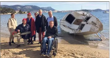  ?? (Photo M. Dalaine) ?? Entourant Yvon Nicol, avec sa tronçonneu­se, des riverains et adhérents du CIL de Balaguier devant l’épave échouée sur le rivage de Balaguier.