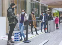  ?? DAVE SIDAWAY ?? Shoppers line up outside Fairview Mall stores in Pointe-claire on Saturday due to store capacity limitation­s.