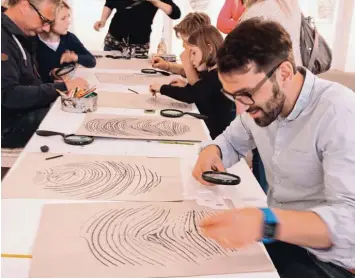  ?? Foto: Sabine Roth ?? Alfred Grießer zeichnet bei der Ausstellun­gseröffnun­g zu „Einzigarti­g“im Kunstwerk seinen Fingerabdr­uck.