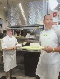  ?? PHOTO COURTESY OF WAHLBURGER­S ?? Alex Rodriguez gets right to work yesterday at Wahlburger­s’ Fenway location.