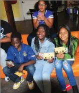  ?? Photo by Ernest A. Brown ?? Youngsters in the after school program at Neighborwo­rks C3 Studio in Woonsocket use their phones Tuesday to vote to bring a summer concert series to Woonsocket. Jose Arias, 13, Mariam Jobe, 11, and Hayley Martinez, 12, seated from left, and Olivia...