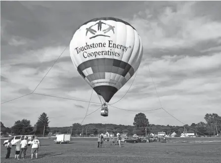  ?? LEONARD HAYHURST/TRIBUNE ?? The Touchstone Energy Cooperativ­es hot air balloon will give tethered rides to visitors at the Coshocton Hot Air Balloon Festival at the Coshocton County Fairground­s. The balloon will go up about 100 feet for a minute or so with passengers before coming back down.