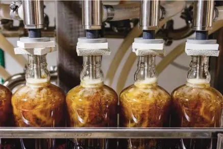  ?? STAFF PHOTOS BY DOUG STRICKLAND ?? Bottles are filled in the bottling line at Chattanoog­a Whiskey Company’s Martin Luther King Boulevard distillery.