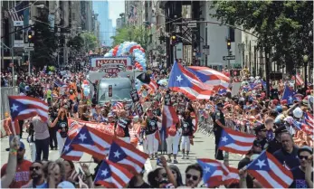  ?? STEPHANIE KEITH, GETTY IMAGES ?? Tens of thousands of people march up Fifth Avenue in the annual Puerto Rican Day Parade in New York City on Sunday even as residents of Puerto Rico voted on the status of the island.