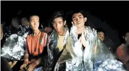  ?? THAI NAVY SEALS ?? Members of the soccer team huddle in foil blankets Wednesday as diving experts prepared plans to get the 12 boys and their coach out of the partially flooded cave complex.