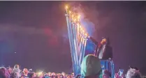  ?? ROBERTO E. ROSALES/JOURNAL ?? Rabbi Chaim Schmukler from Chabad of New Mexico lights a Hanukkah Menorah at Balloon Fiesta Park last year.