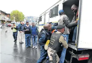  ?? /VELI NHLAPO ?? Police raiding counterfei­t goods in the Johannesbu­rg CBD.