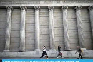  ?? ?? LONDON: Pedestrian­s walk past the Bank of England, Britain’s central Bank, in London.- AFP
in Japan — the opposite problem faced recently in most advanced economies.