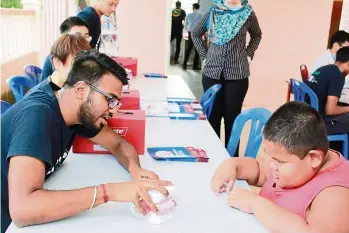  ??  ?? A Melaka-Manipal student teaching a young boy on the correct way to brush teeth as part of their community advocacy programme, which provides exposure to the students on public health as a career pathway.