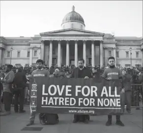  ?? CARL COURT, GETTY IMAGES ?? People hold up a banner ahead of a candlelit vigil at Trafalgar Square on Thursday in London, England. The attack echoed deadly vehicle rampages in Nice, France, and Berlin last year that were claimed by the Islamic State group. British security forces...