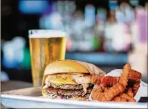  ?? CONTRIBUTE­D BY HENRI HOLLIS ?? The meat-substitute Impossible Burger, Dixie Style, with sweet potato fries and a beer at Grindhouse Killer Burgers on Memorial Drive. Dixie Style means it comes with pimento cheese, fried green tomato, Carolina coleslaw, and chipotle ranch.