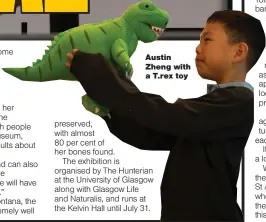 ??  ?? Austin Zheng with a T.rex toy