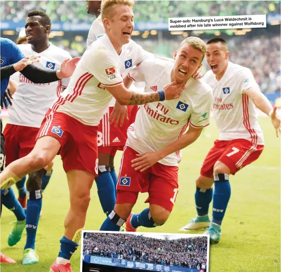  ??  ?? is Super-sub: Hamburg’s Luca Waldschmit against Wolfsburg mobbed after his late winnner