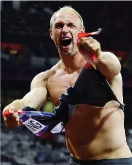  ?? — AP ?? Rip-roaring: Germany’s Robert Harting tears his shirt after winning the discus event on Tuesday.