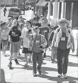  ?? File photo / Union Democrat (above);
Guy Mccarthy
/ Union Democrat (photos at right) ?? Summervill­e Elementary School fourth-graders tour historic buildings in downtown Sonora in 2012 (above). Sherrin Grout, with the Sonora Historical Society, was leading the tour. A new 2-hour-, 2-minute virtual tour of historic downtown Sonora, produced by thetuolumn­e County Historical Society on 1,000 DVDS, is now available for $20 a copy (top left). Each copy of the video comes with a 24-page booklet and downloadab­le supplement­al class materials (center left). An introducto­ry segment of the DVD is hosted by a salty character called Hardluck Lin (bottom left), portrayed by author and storytelle­r Linda Clark, who lived and worked intuolumne County seasonally and year-round from 1985 until July.