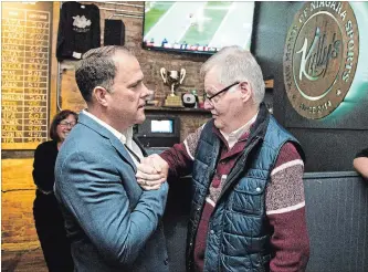  ?? BOB TYMCZYSZYN THE ST. CATHARINES STANDARD ?? Walter Sendzik, left, is congratula­ted by Mike Thomson after being re-elected mayor of St. Catharines.