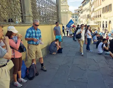  ??  ?? I turisti che dopo l’intervento degli idranti si sono spostati per mangiare sui gradini laterali della Basilica di Santa Croce