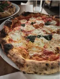  ?? Mary Ann Anderson/TNS ?? ■ Wood-fired, sourdough-based Neapolitan-style pizza is the specialty of A Dopo. The mozzarella is handmade, too, as seen here in the Margherita, a bubbly concoction full of flavor that includes basil and olive oil.