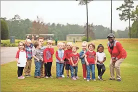  ?? David Johnson ?? RFCCY Executive Director Ladonna Collins poses for a photo with children from Reach for the Stars Child Care Center, who opened the tournament by singing the national anthem.