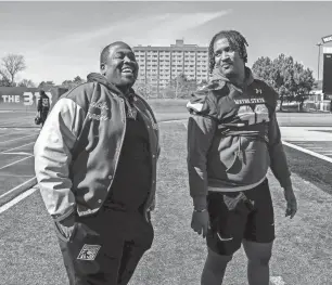  ?? PHOTOS BY DAVID RODRIGUEZ MUNOZ/DETROIT FREE PRESS ?? Marcus Green, left, the athletic director and head football coach at Cornerston­e Lincoln-King High School, smiles as he stands next to Jordan Hutchinson during practice at Wayne State on Friday.