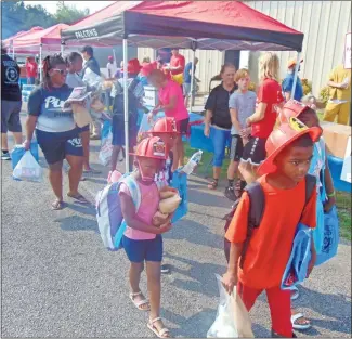  ?? Brandon Dyer ?? Rome resident Shrie Young (left) takes her family to the Give A Kid A Chance event Saturday at the Floyd County Jail to pick up school supplies and bookbags.