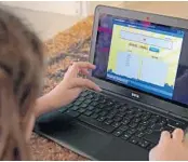  ?? JOHN MCCALL/SOUTH FLORIDA SUN SENTINEL ?? Lacey Wolf plays a spelling game at home in Fort Lauderdale after classes at Pine Crest School were canceled.