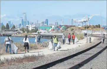  ?? PHOTOS BY RAY CHAVEZ — STAFF PHOTOGRAPH­ER ?? Volunteers pick up trash as they take part in the 34th annual California Coastal Cleanup Day at Middle Harbor Shoreline Park in Oakland on Saturday.