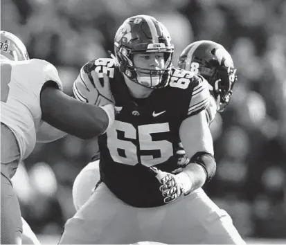  ?? ?? Iowa offensive lineman Tyler Linderbaum (65), making a block against against Illinois last season, was selected by the Ravens in the first round of the draft on Thursday night.