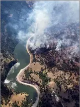  ?? CP HANDOUT COURTESY BC WILDFIRE SERVICE ?? Smoke from a wildfire is visible along Highway 3A at the north end of Yellow Lake in B.C. in a Wednesday handout photo.