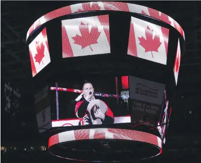  ?? JIM WELLS ?? Country singer George Canyon is seen on the Saddledome scoreboard singing the national anthem earlier this month. Readers have written in to express their opposition to a suggestion that a reference to God should be removed from the O Canada lyrics.