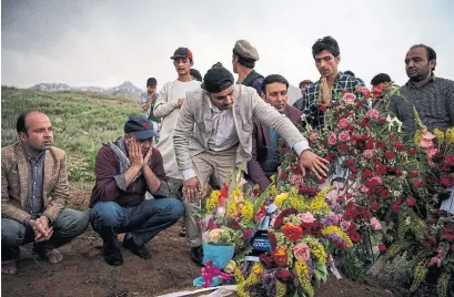  ?? ANDREW QUILTY/AFP/GETTY IMAGES ?? Friends and relatives of AFP’s chief photograph­er in Kabul, Shah Marai, gather at his burial on Monday.