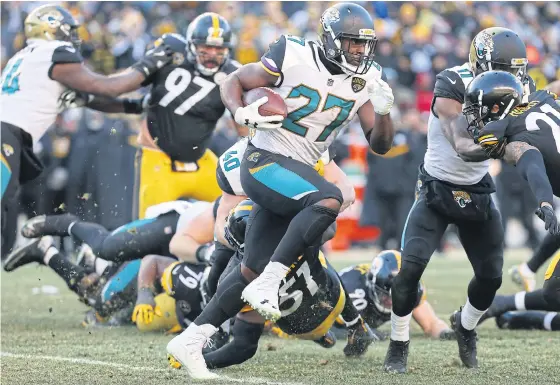  ??  ?? The Jaguars’ Leonard Fournette carries the ball past the Steelers’ defence.