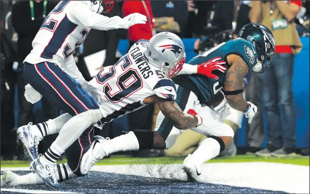  ?? GETTY IMAGES ?? Eagles’ Corey Clement catches a 22-yard touchdown pass in front of Patriots’ Marquis Flowers and Patrick Chung in Minneapoli­s last night.